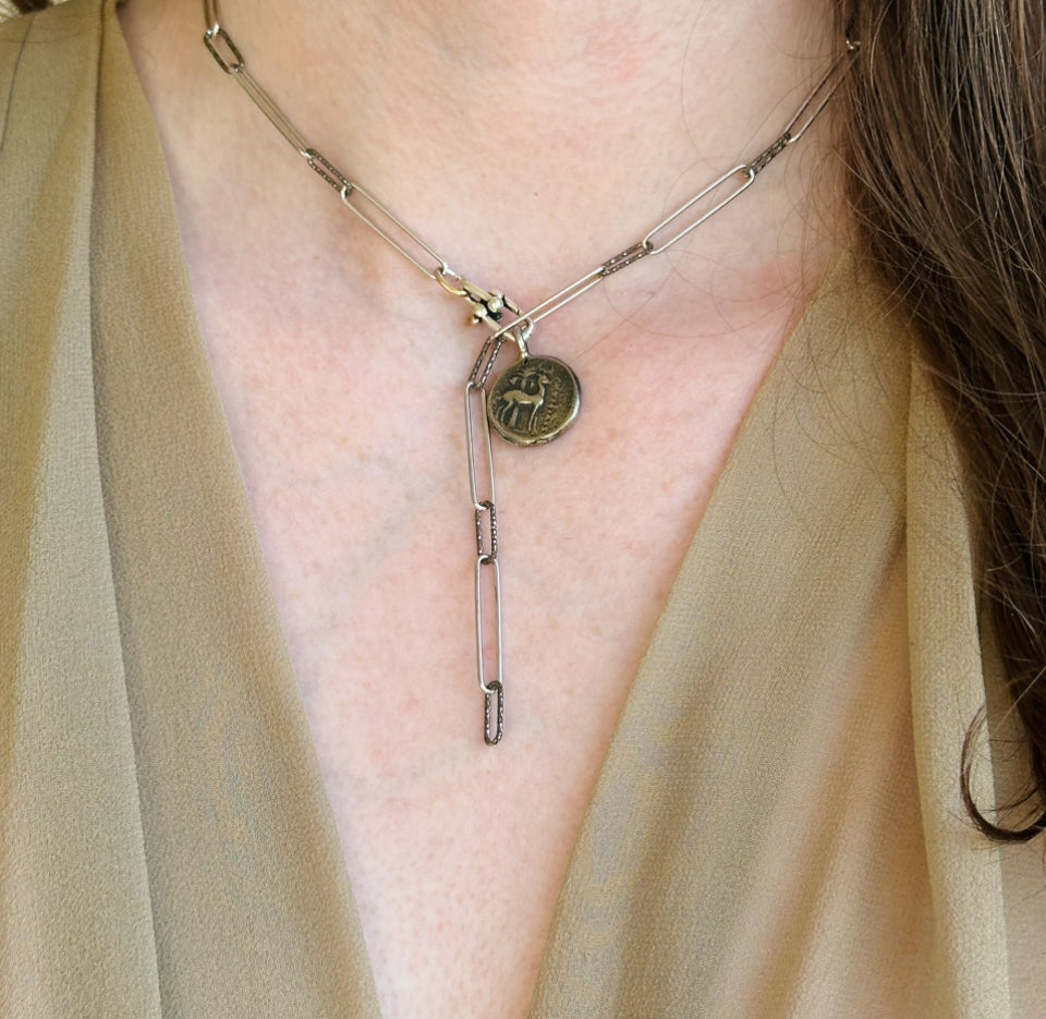model-wearing-a-paper-clip-necklace-two-tone-silver-and-gun-metal-hammered-with-a-coing-pendant-small-in-silver-belaroca-ejewelry