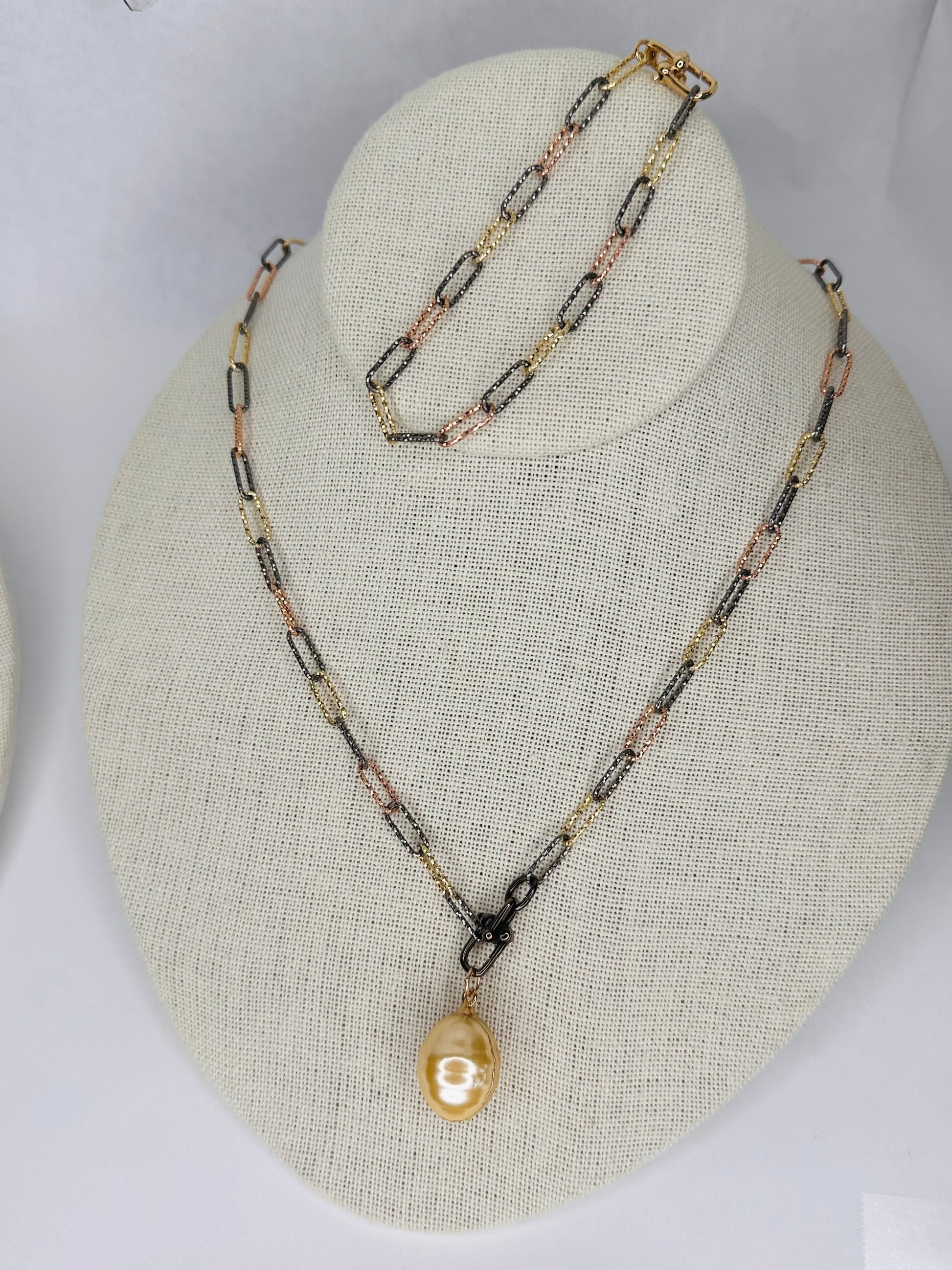 display-of-a-paper-clip-multi-tone-necklace-and bracelet-with -a-pearl-pendant-hanging-from-necklace-belaroca-jewelry